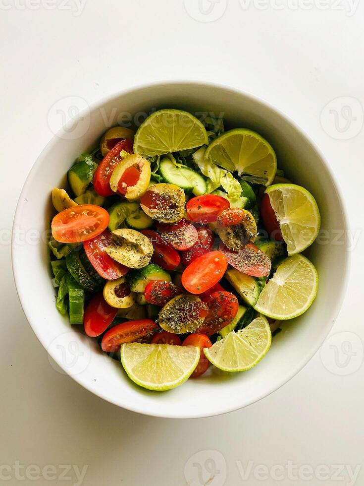 salada com pepino, tomate, Pimenta e Lima em branco fundo foto