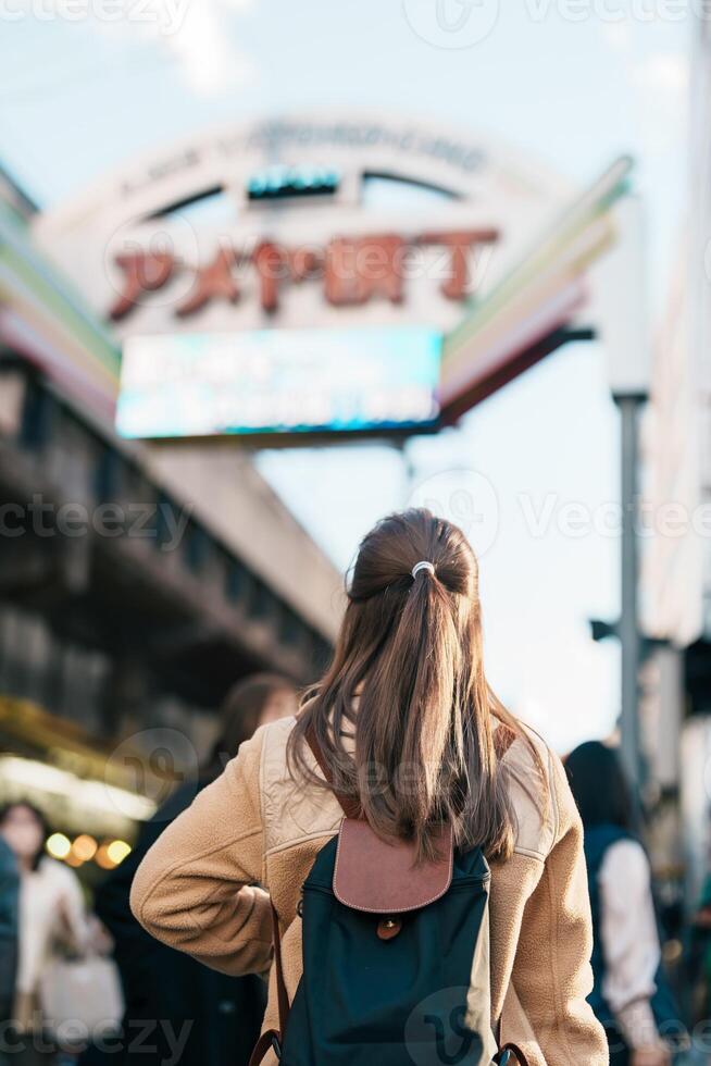 turista mulher Visita ameyoko mercado, uma ocupado mercado rua localizado dentro ueno. ponto de referência e popular para turista atração e viagem destino dentro Tóquio, Japão e Ásia conceito foto