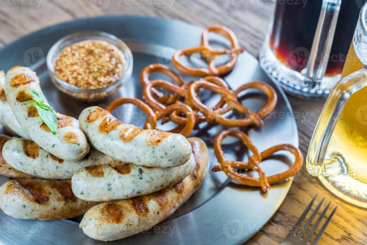 grelhado salsichas com salgadinhos e canecas do Cerveja foto