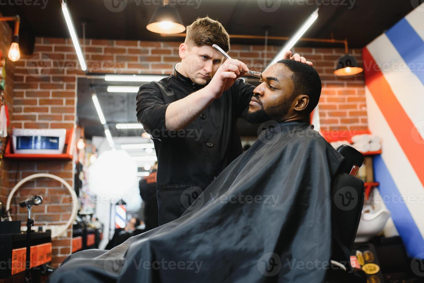 jovem afro-americano homem visitando barbearia foto