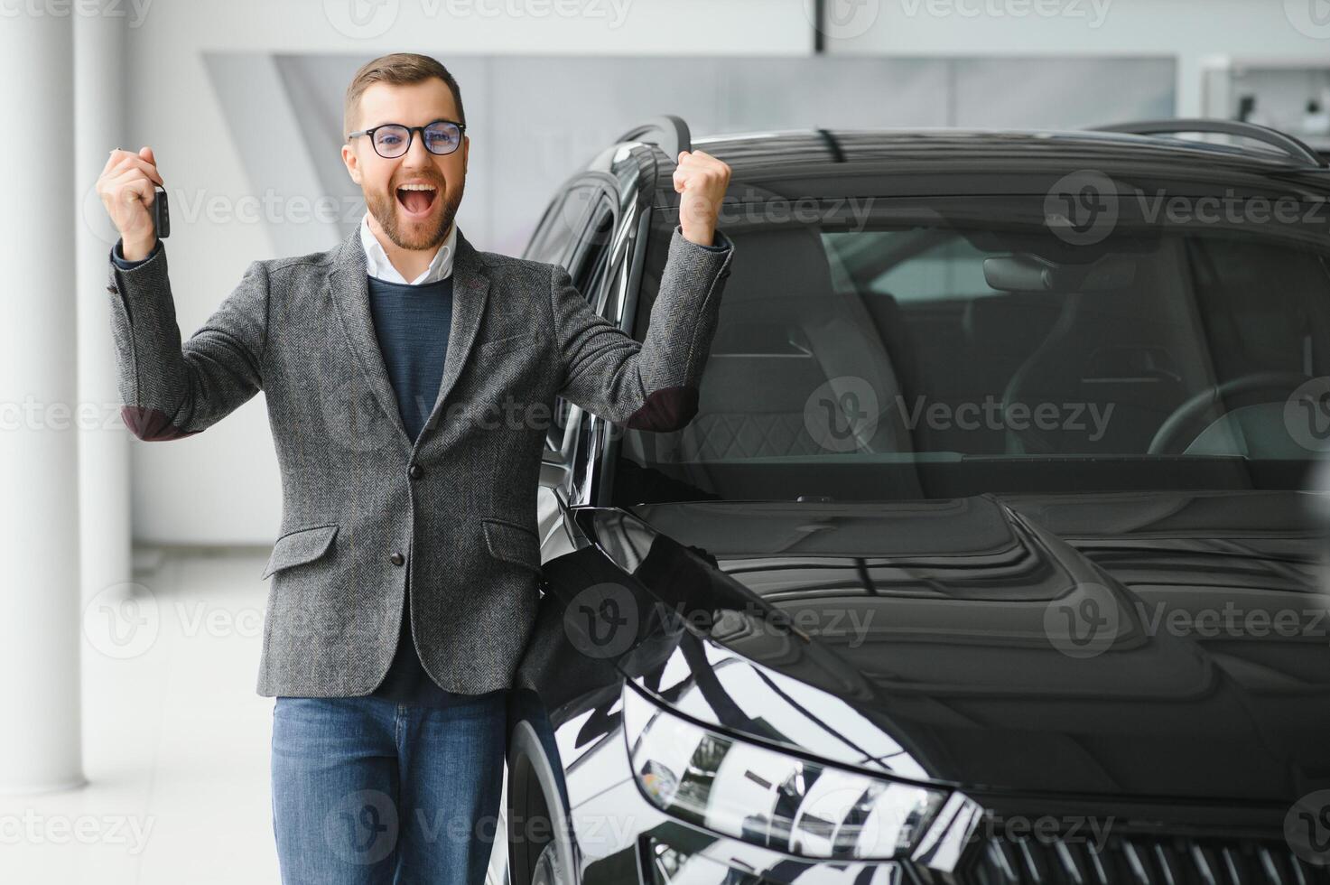 sim, isso é meu Novo carro. cliente dentro carro concessionária. jovem homem ajoelhou-se baixa com chaves dentro mão. foto