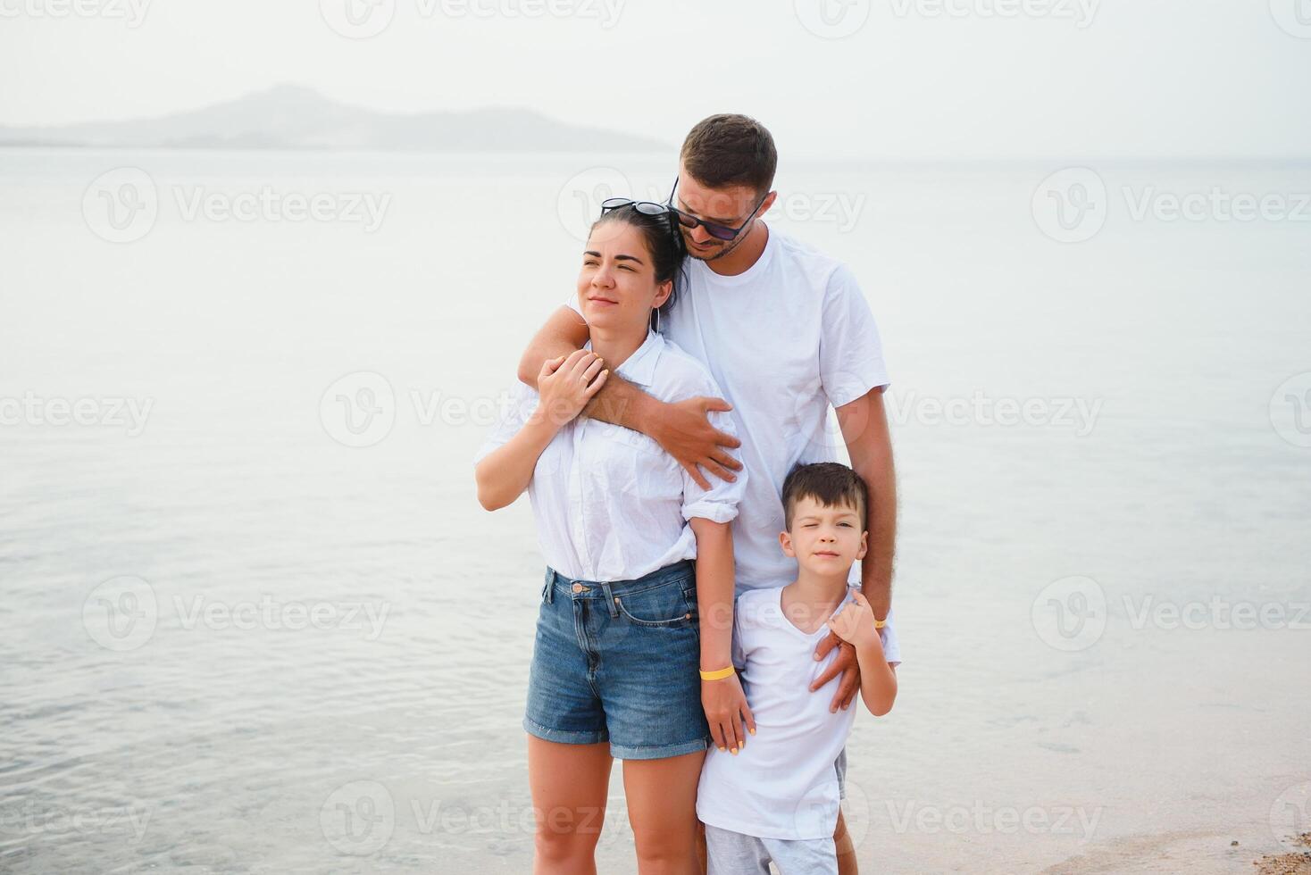 família feliz caminhando na praia foto