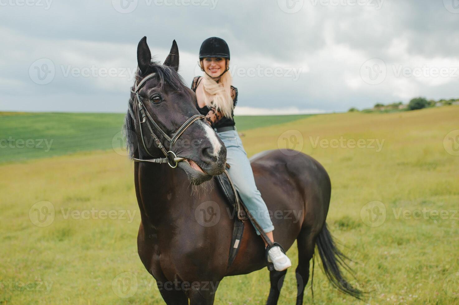 jovem mulher equitação uma cavalo em a verde campo foto