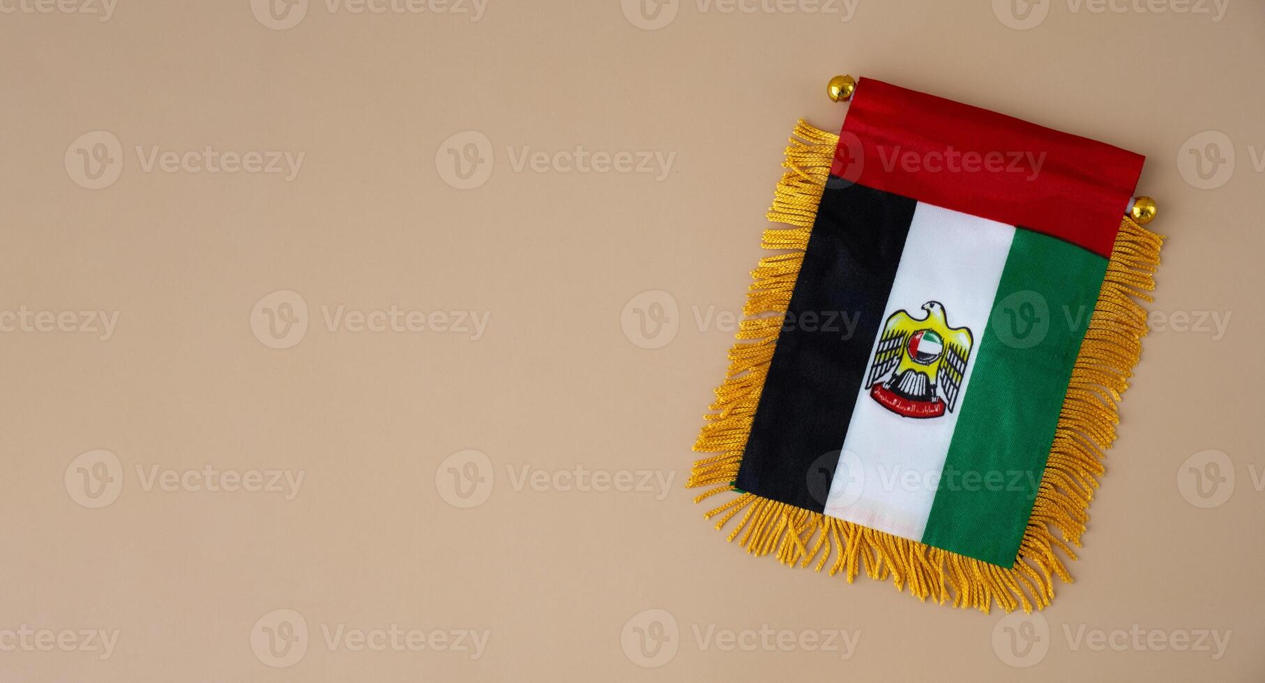 nacional símbolo do uae. Unidos árabe Emirados pequeno bandeira com peregrino falcão em neutro bege fundo. cópia de espaço para seu texto. conceito do nacional dia independência foto