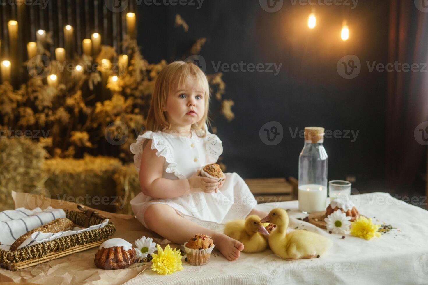 uma pequeno menina é sentado em a Páscoa mesa e jogando com fofa fofo patinhos. a conceito do a comemorar feliz Páscoa. foto