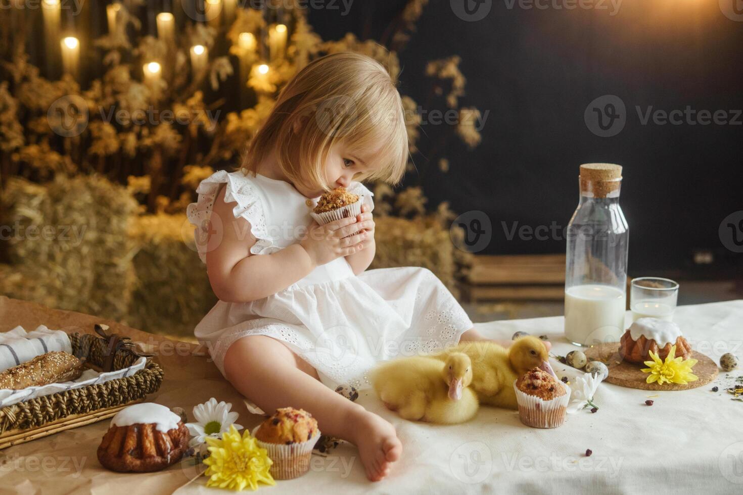 uma pequeno menina é sentado em a Páscoa mesa e jogando com fofa fofo patinhos. a conceito do a comemorar feliz Páscoa. foto