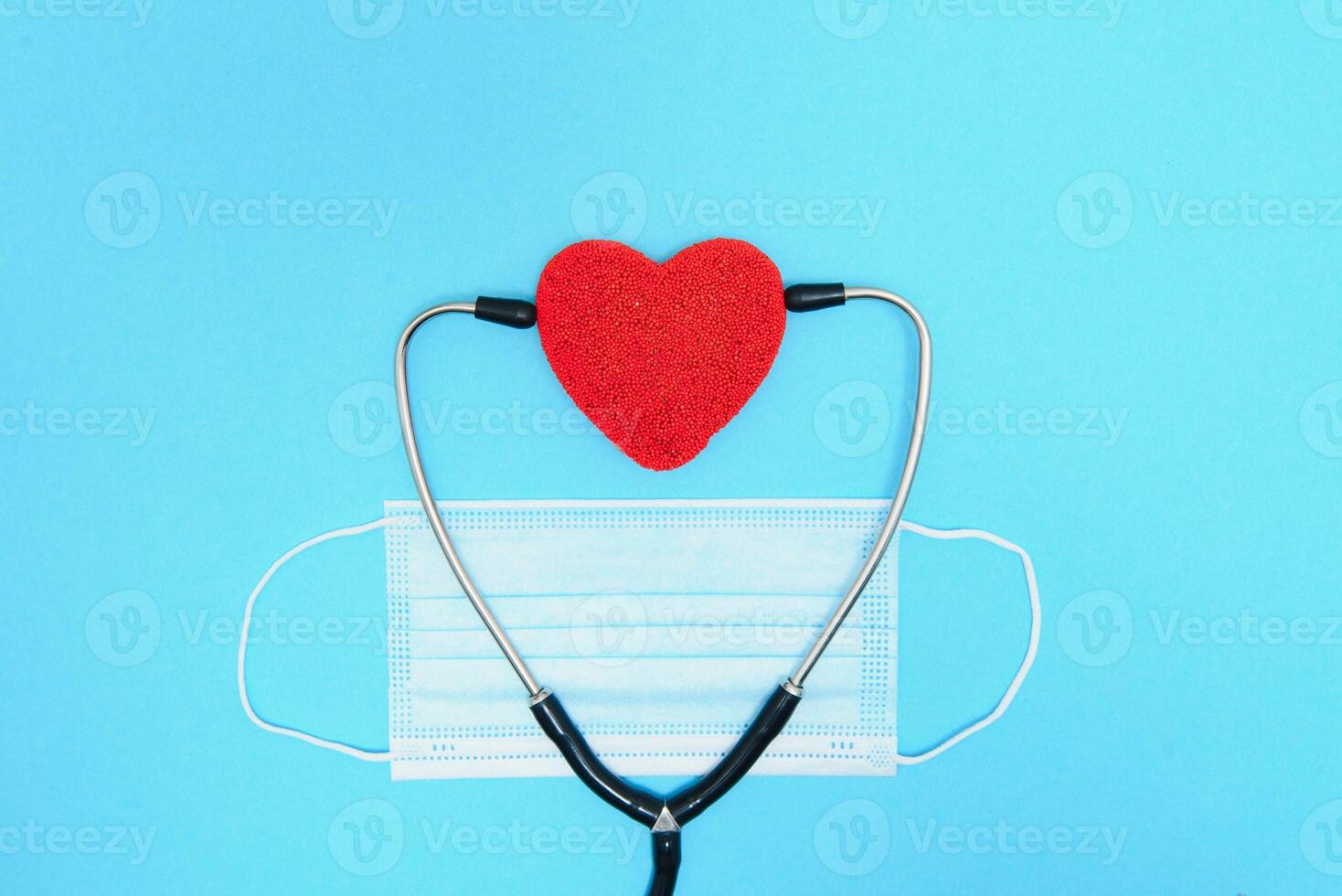 global cuidados de saúde conceito.elegante médico com coração em azul plano de fundo. close-up do vermelho coração e estetoscópio em uma azul fundo. ouço para a coração com estatoscópio foto