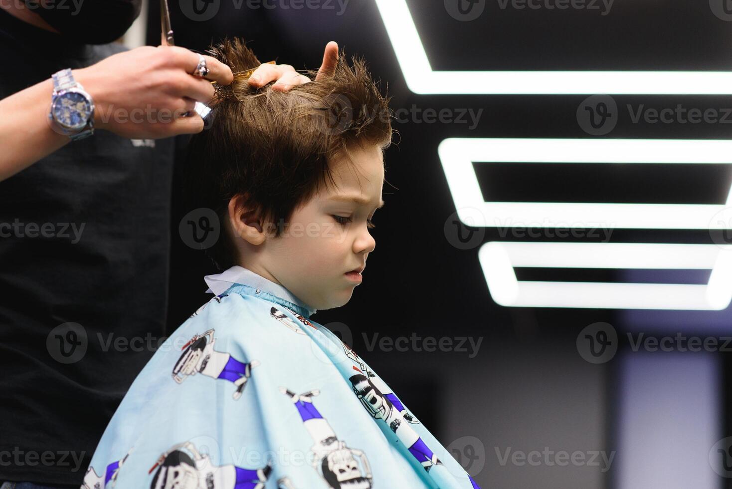 alegre caucasiano Garoto obtendo Penteado dentro barbearia foto