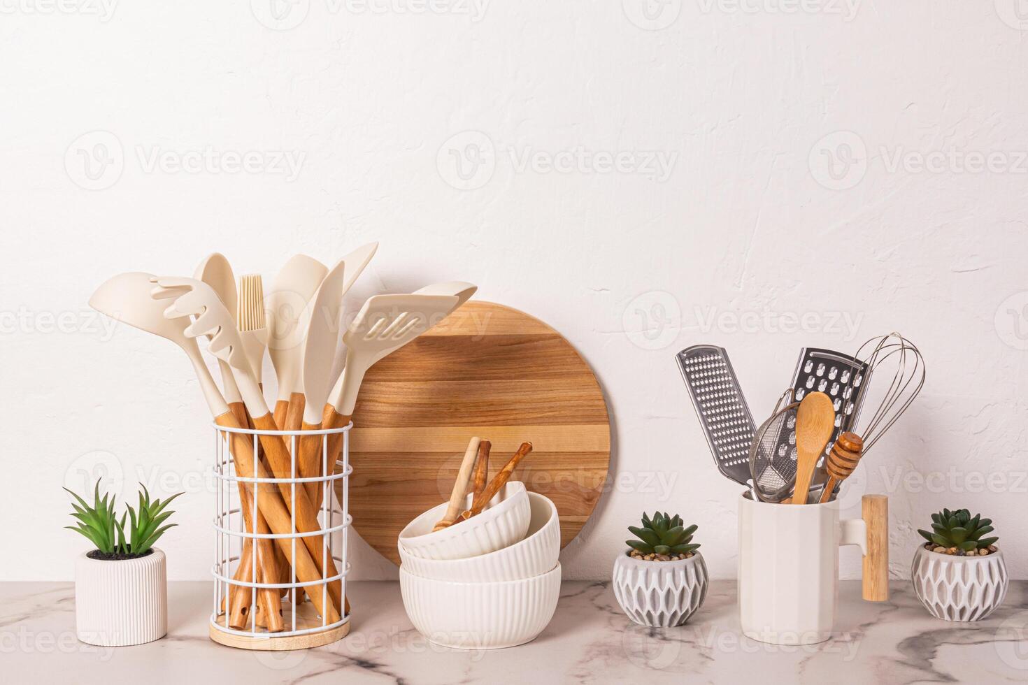 uma conjunto do metal e de madeira cozinhando ferramentas, cozinha utensílios em uma pedra bancada. plantas. natural materiais, ecológico cozinha. foto