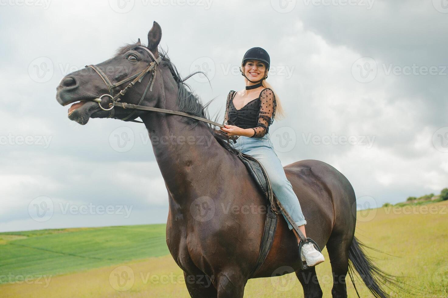 jovem mulher equitação uma cavalo em a verde campo foto