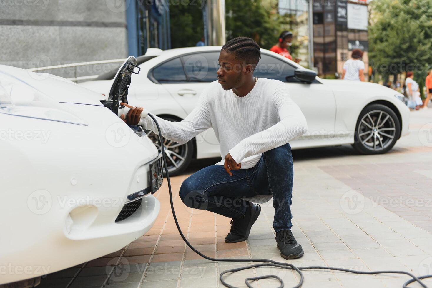 africano americano homem cobrando dele elétrico carro. foto