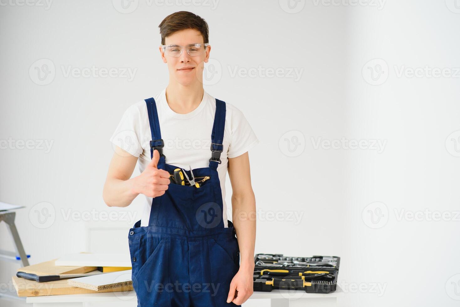 reparar, construção e construção conceito - feliz sorridente masculino trabalhador ou construtor dentro óculos às Novo casa em fundo foto