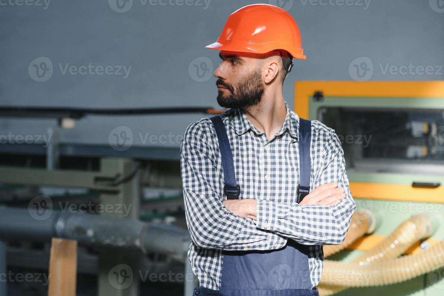 retrato do profissional pesado indústria engenheiro trabalhador vestindo segurança uniforme, Difícil chapéu sorridente. dentro a fundo desfocado ampla industrial fábrica. foto