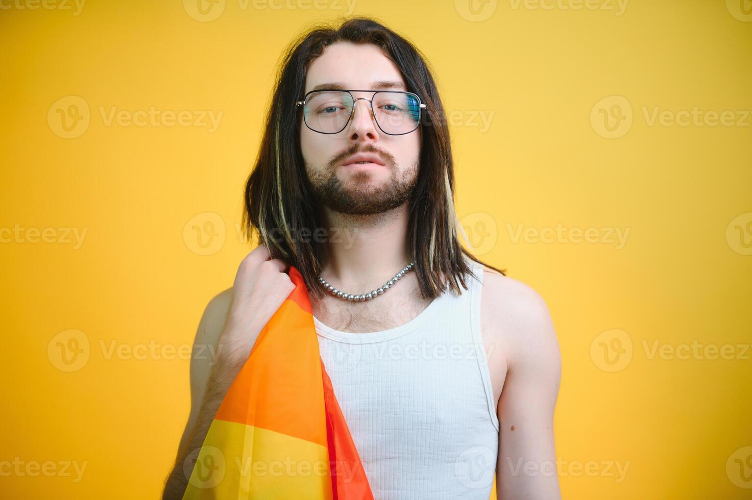 bonito jovem homem com orgulho movimento lgbt arco Iris bandeira em ombro contra branco fundo. homem com uma gay orgulho bandeira. foto