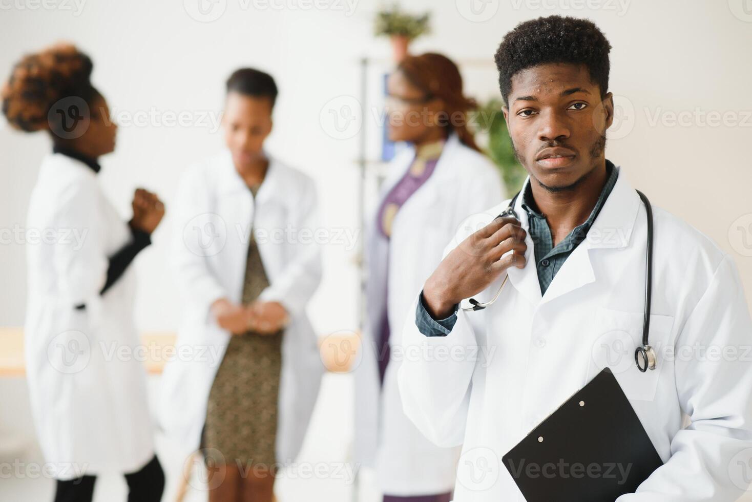 retrato do uma africano médico dentro frente do dele médico equipe. foto
