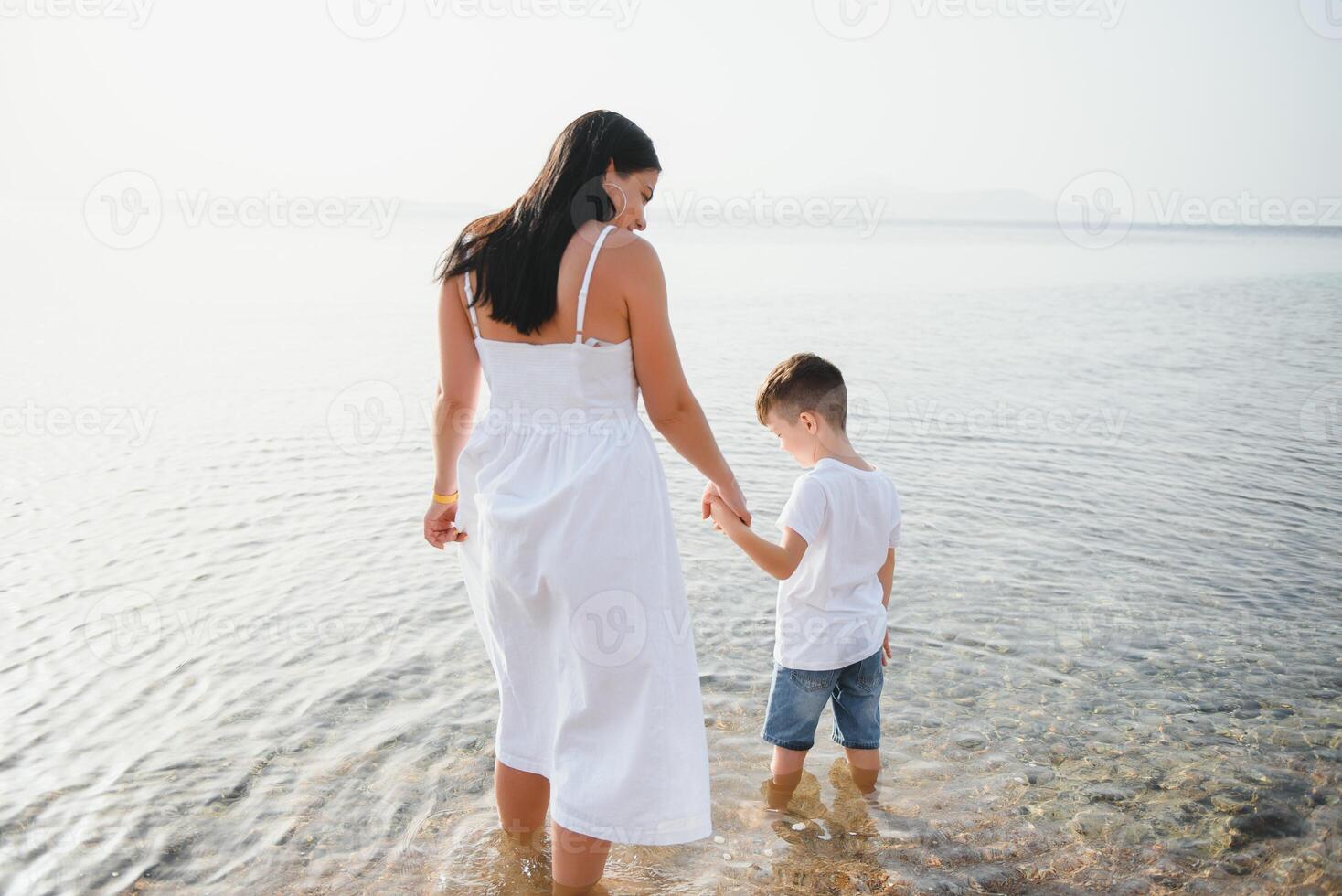 mãe e filho jogando em a de praia às a dia tempo. conceito do amigáveis família. foto