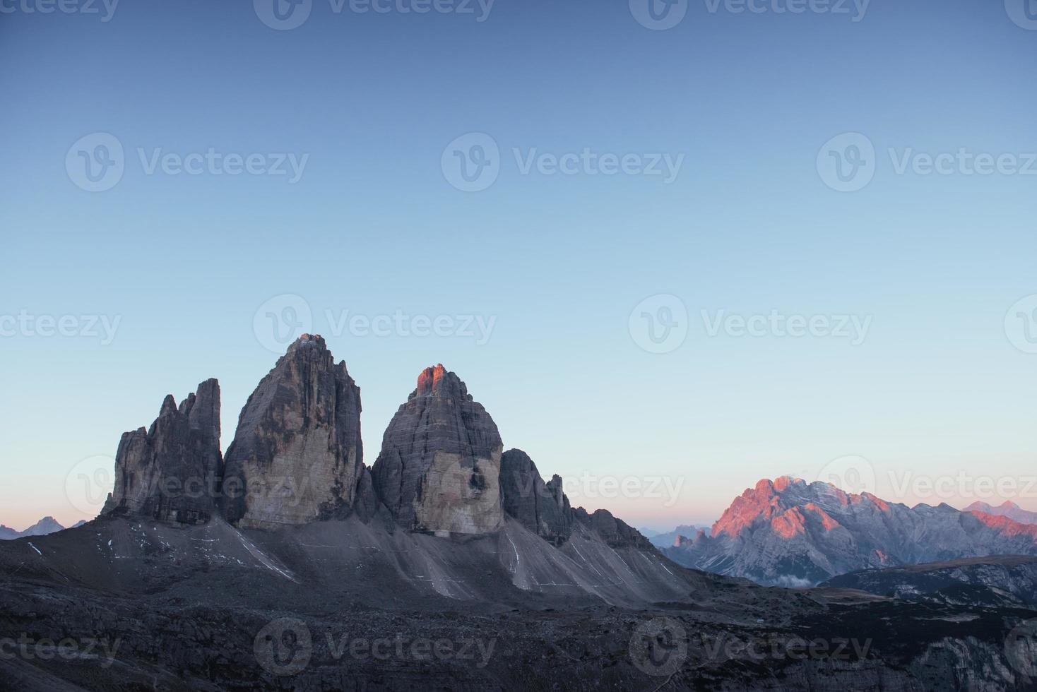 o dia começa. três picos tre cime montanhas pela manhã com céu claro sobre ele foto