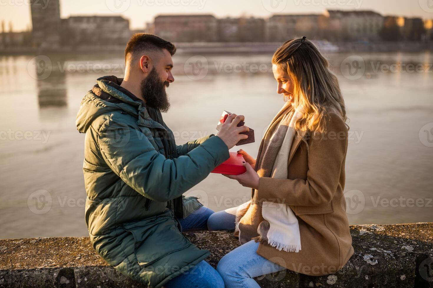 homem dando apresenta para dele mulher enquanto elas apreciar gastos Tempo juntos ar livre. foto