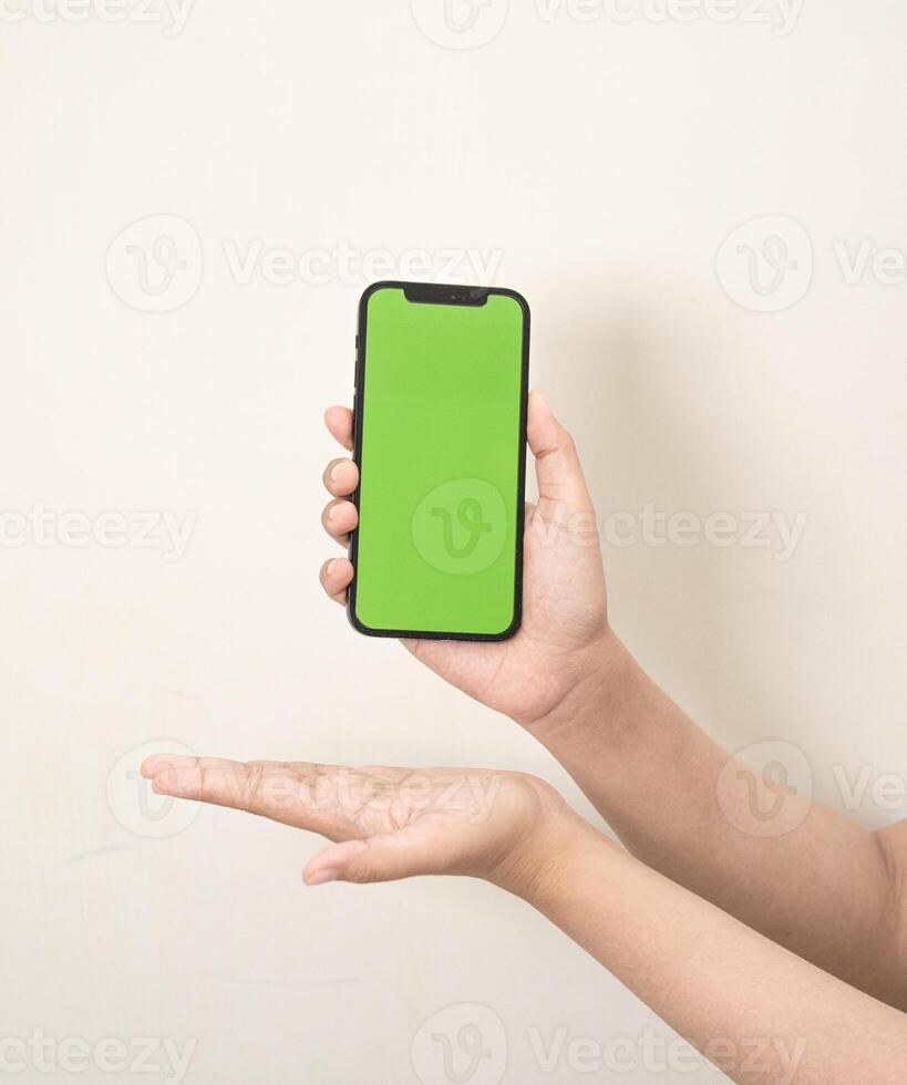 mão é segurando uma telefone com verde tela em uma branco isolado fundo foto