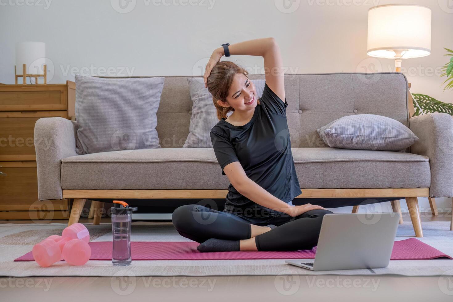 jovem ásia desportivo ginástica mulher treinador Faz prática vídeo conectados Treinamento ioga computador portátil dentro vivo quarto às casa foto