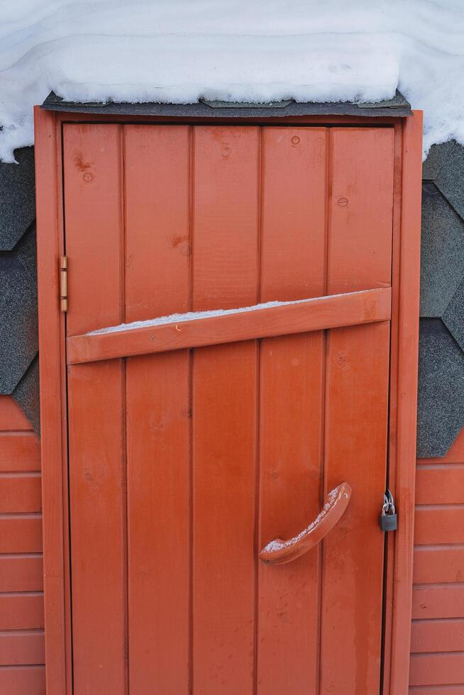 a de madeira porta é tiro fechar-se. há uma trava em a porta. Entrada para a banho barril. foto