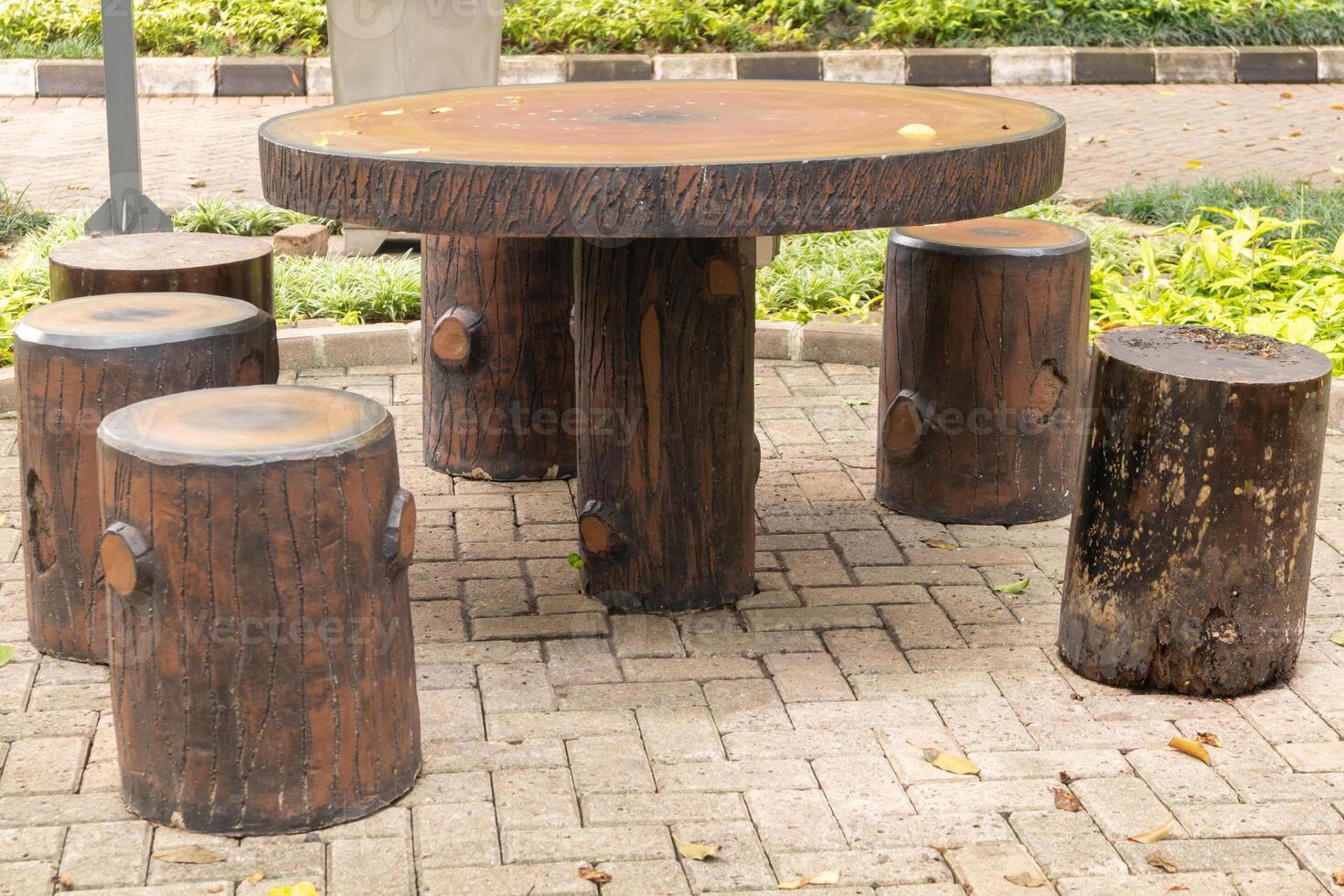 pedra mesa e bancos com madeira textura dentro a jardim foto