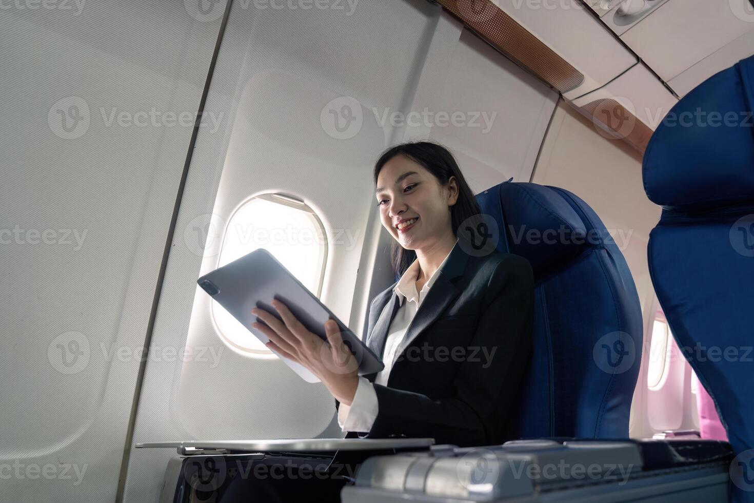 bem sucedido jovem ásia o negócio mulher senta dentro avião cabine avião e trabalhando a partir de em qualquer lugar. vôo às primeiro classe foto