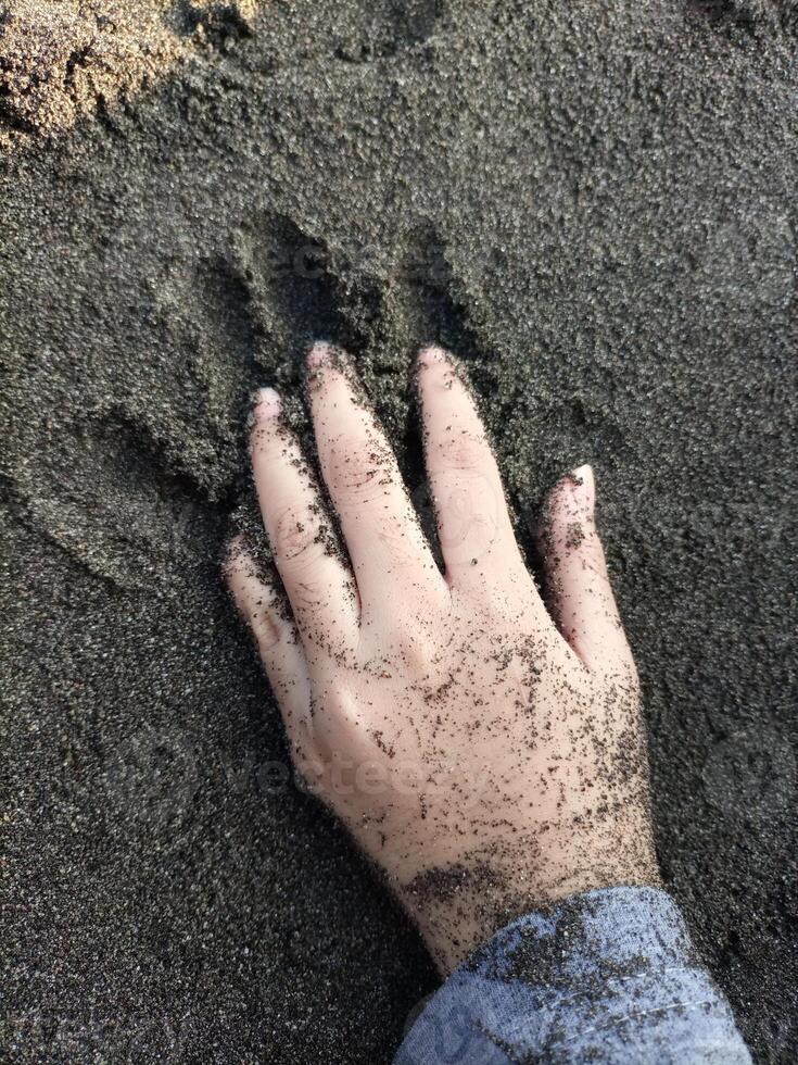 criança jogando dentro a areia em a de praia foto