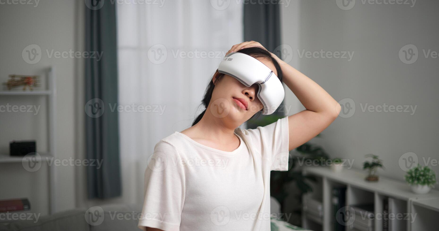 seletivo foco, feliz jovem mulher vestem vr óculos em pé é alongamento dela pescoço às casa com olhos fechado, relaxante corpo e mente sozinho dentro a vivo quarto, relaxamento estilo de vida foto