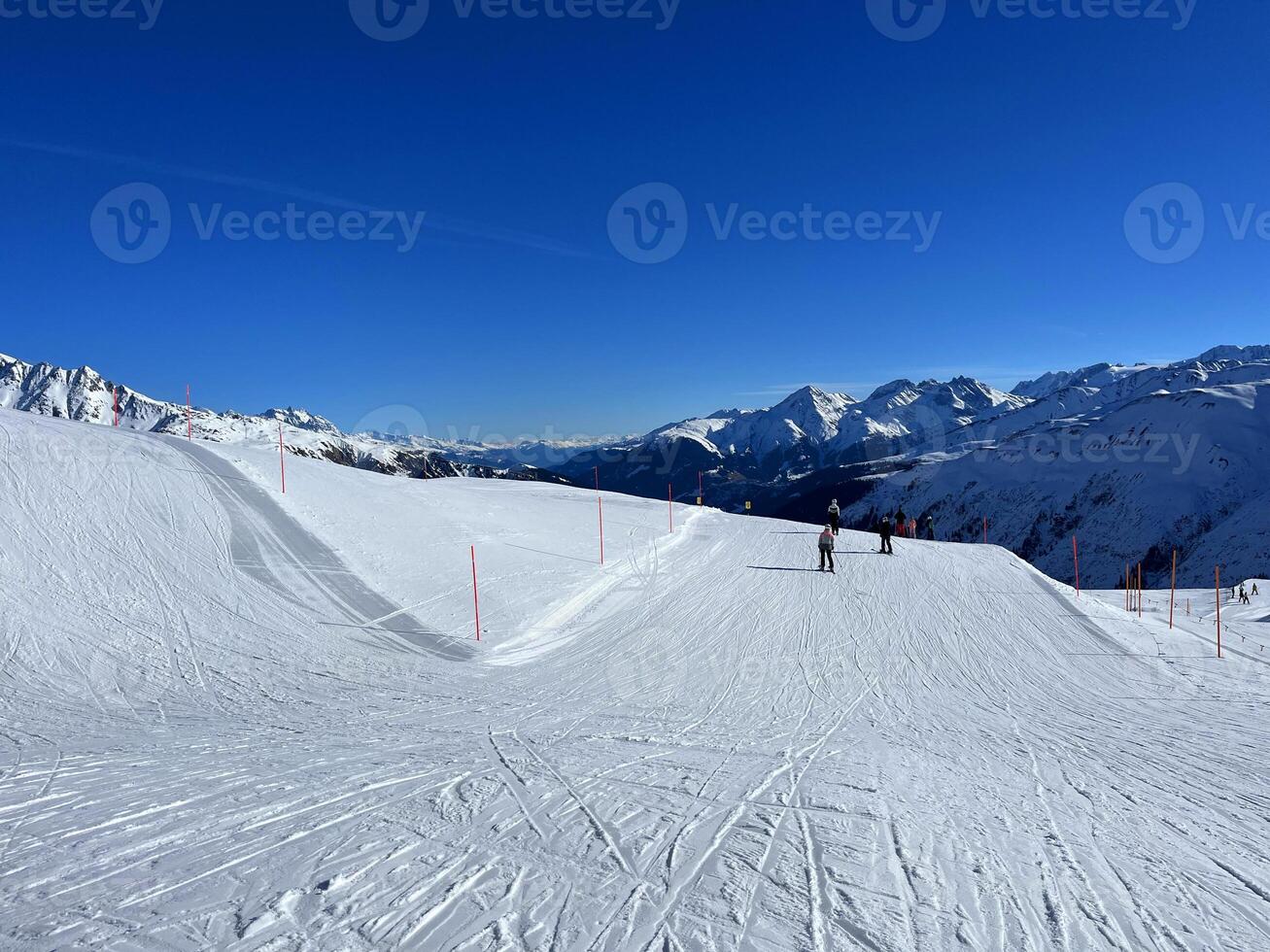 uma esqui declive com pessoas em esquis e neve foto