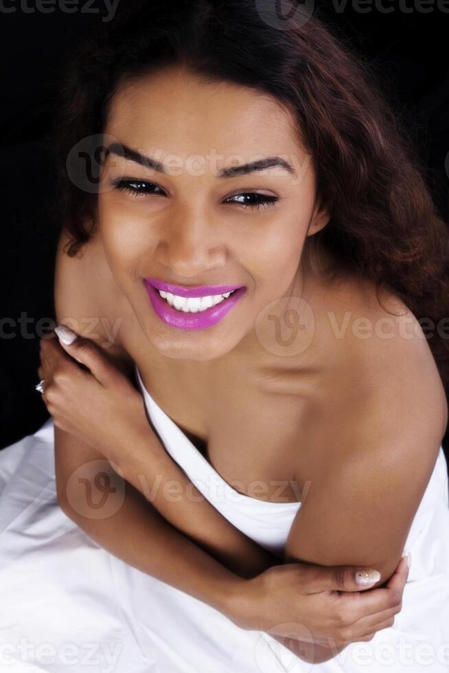 sorridente atraente latina mulher embrulhado dentro Folha foto
