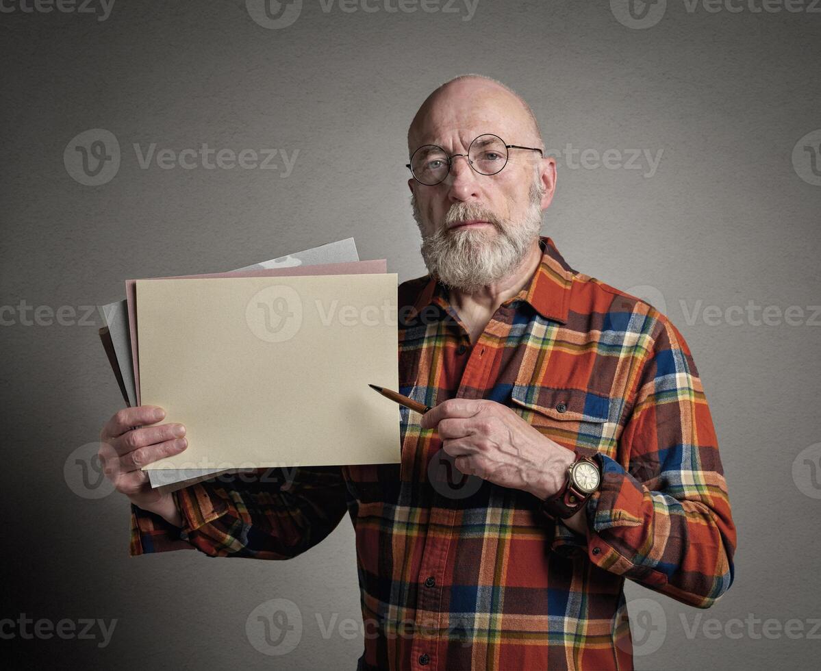 Senior homem é segurando uma em branco Folha do papel e uma caneta, apresentação ou ensino conceito foto