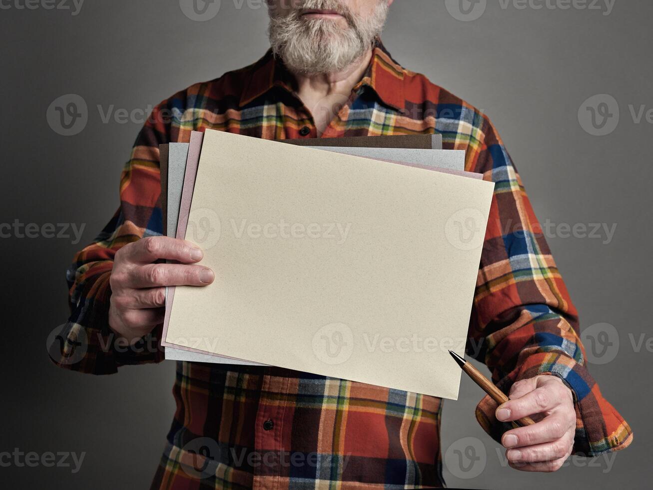 Senior homem é segurando uma em branco Folha do papel e uma caneta, apresentação conceito foto