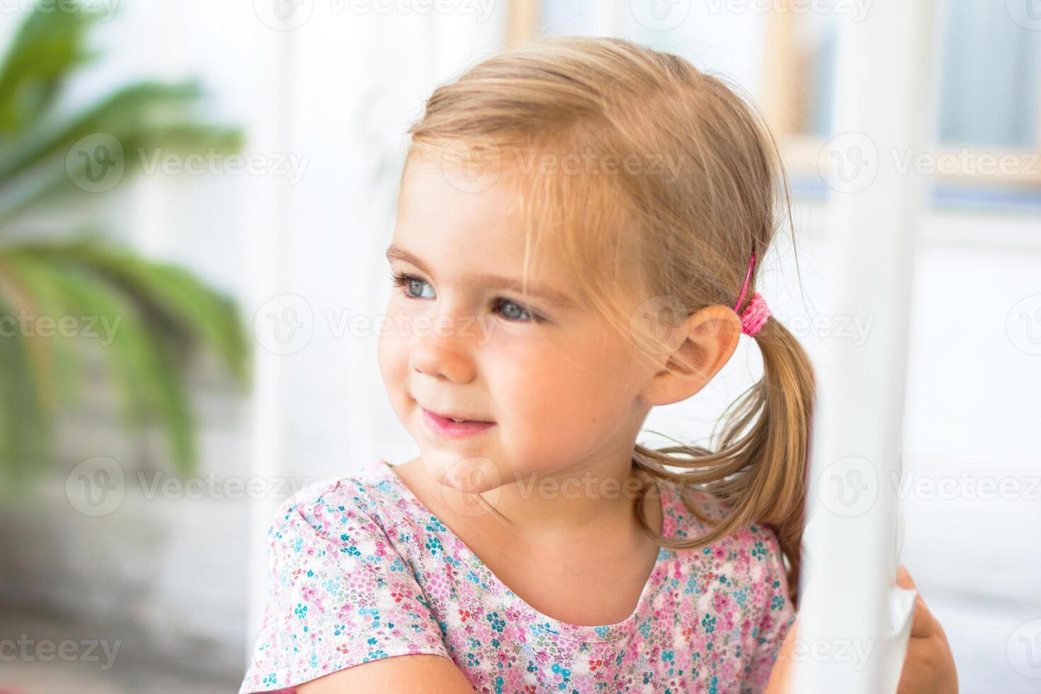 retrato do uma feliz Loiras menina com uma rabo de cavalo sorridente e fazer olho contato com a Câmera. foto