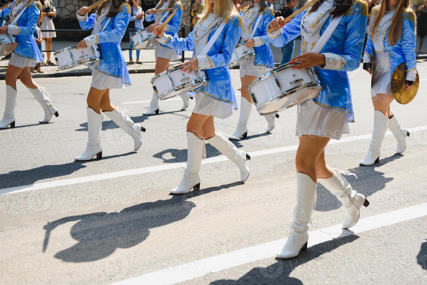 majorettes com branco e azul uniformes executar dentro a ruas do a cidade. fotográfico Series foto