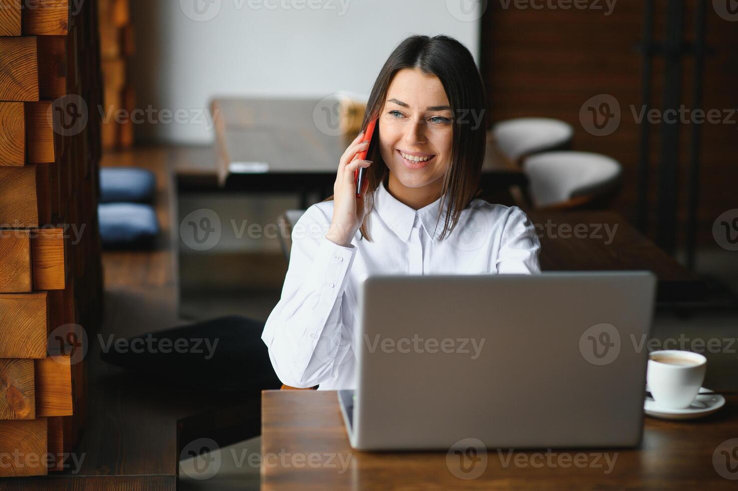 retrato do uma jovem fêmea trabalhador autonomo usando computador portátil computador para distância trabalho enquanto sentado dentro moderno café fazer compras interior, inteligente Loiras mulher trabalhando em netbook durante manhã café da manhã dentro cafeteria Barra foto