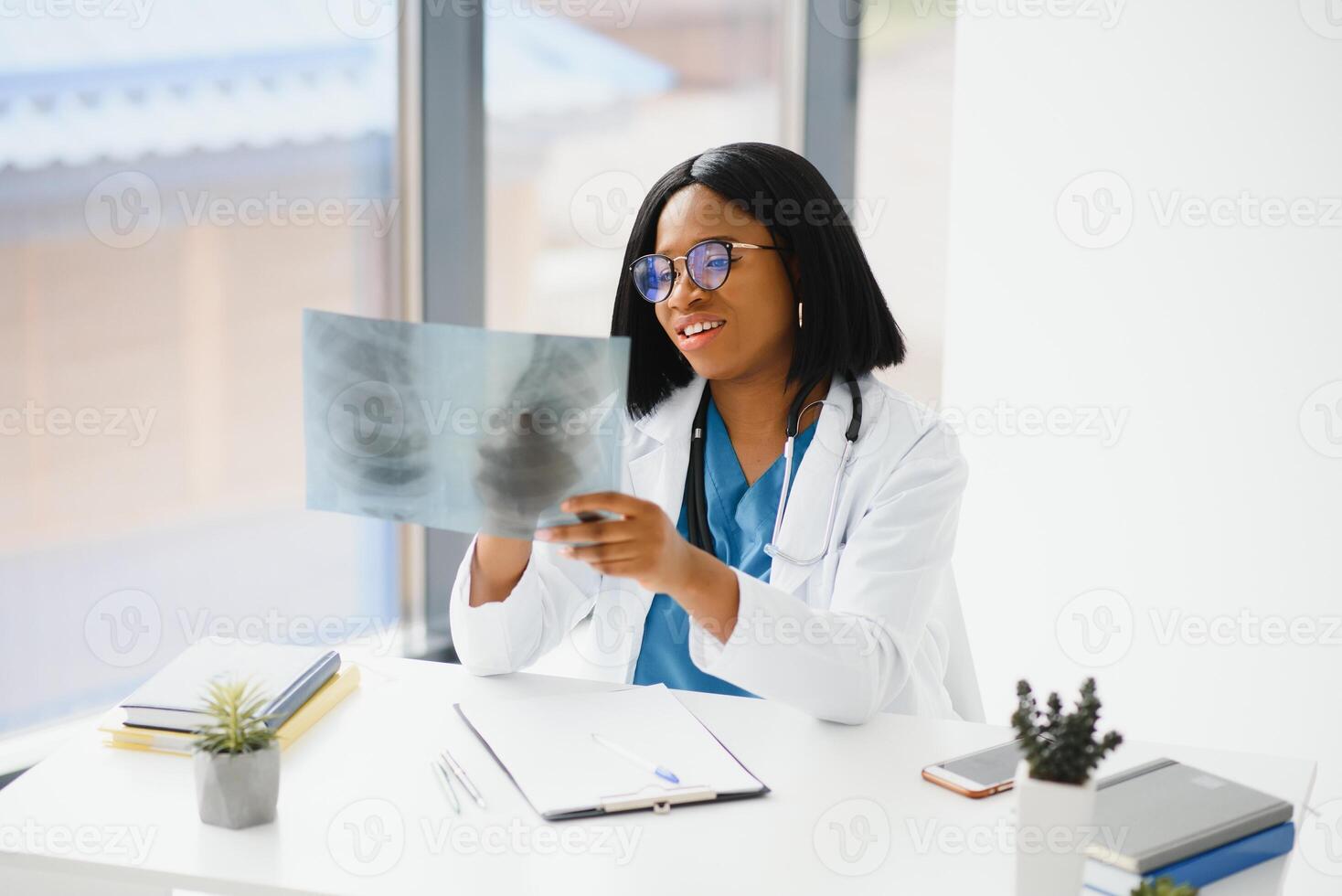 lindo fêmea africano médico trabalhador segurando raio X. foto