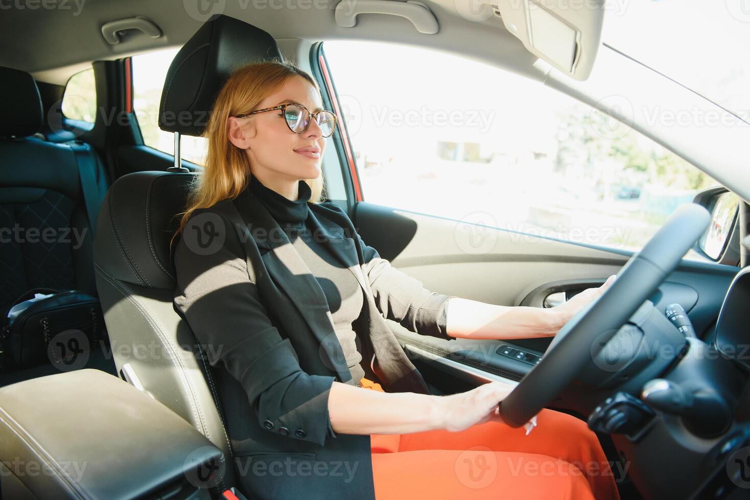 lindo maduro mulher dentro o negócio terno dirigindo uma carro para escritório. empresária dirigir uma carro dentro cidade. foto