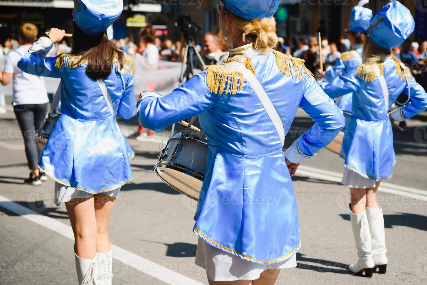 majorettes com branco e azul uniformes executar dentro a ruas do a cidade. fotográfico Series foto