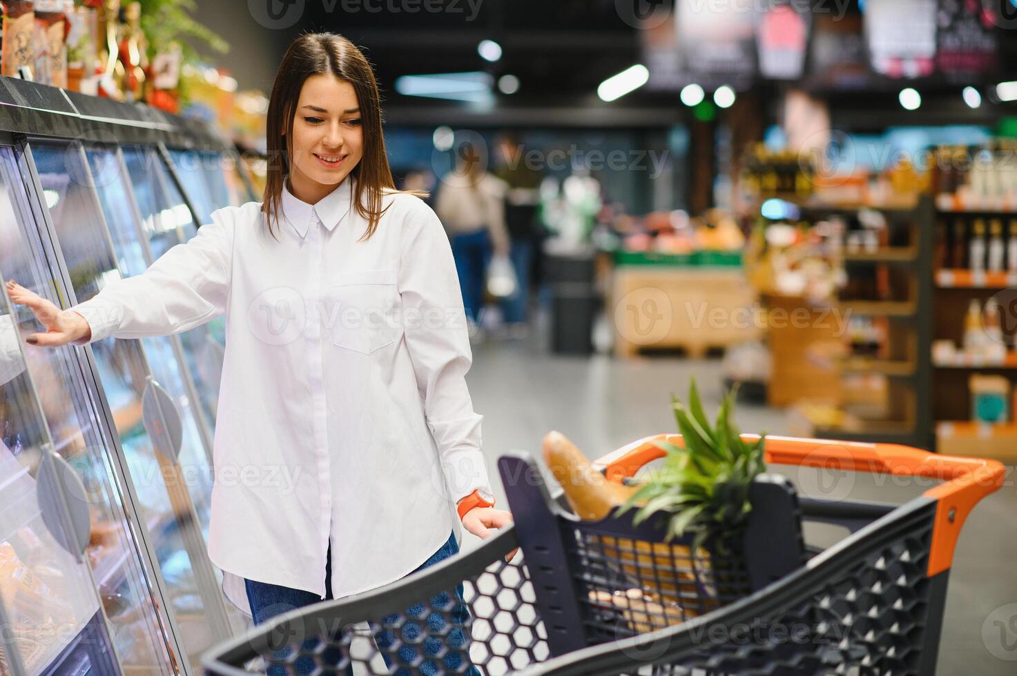 mulher jovem e bonita comprando cereais, a granel em um supermercado foto