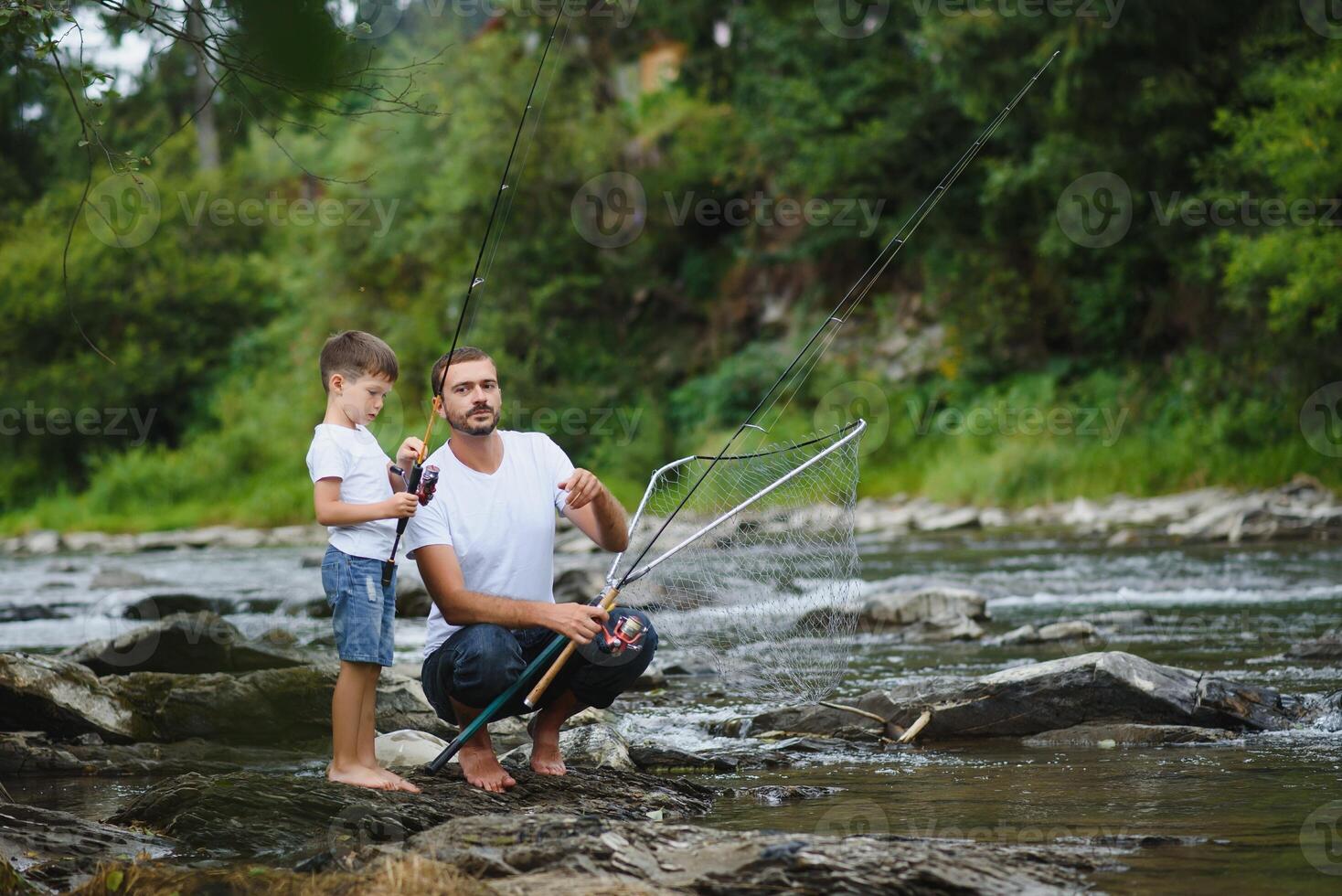 uma pai ensino dele filho quão para peixe em uma rio lado de fora dentro verão luz do sol. do pai dia. foto