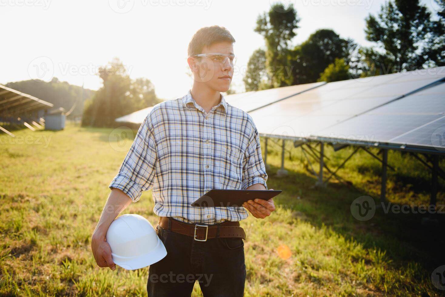 inspetor engenheiro homem segurando digital tábua trabalhando dentro solar painéis poder fazenda, fotovoltaico célula parque, verde energia conceito foto