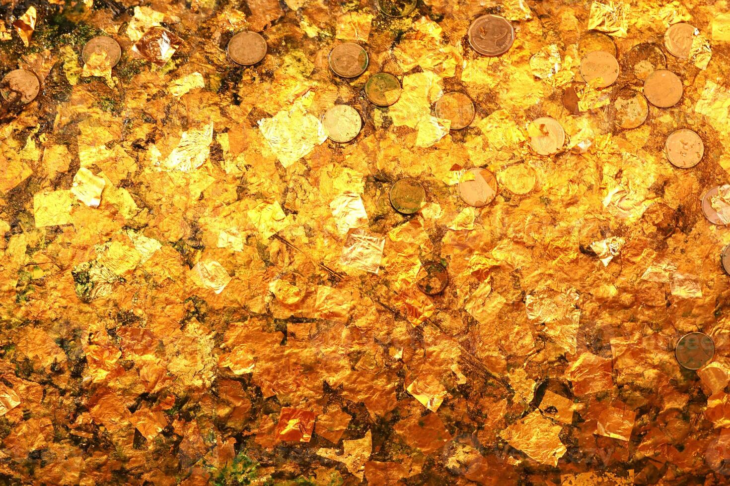 ouro folha textura ou fundo. ouro folha e moeda em Buda foto