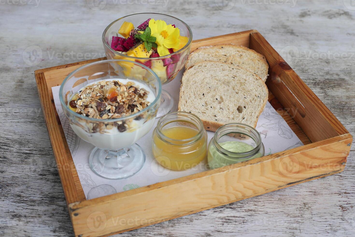 saudável refeição com frutas, alho pão e leite com nozes servido dentro prato isolado em de madeira fundo topo Visão do café da manhã foto