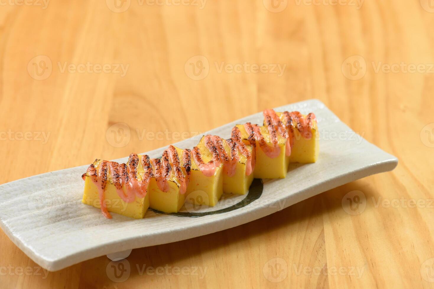 japonês Comida tamagoyaki dentro uma branco prato isolado em de madeira mesa topo Visão foto