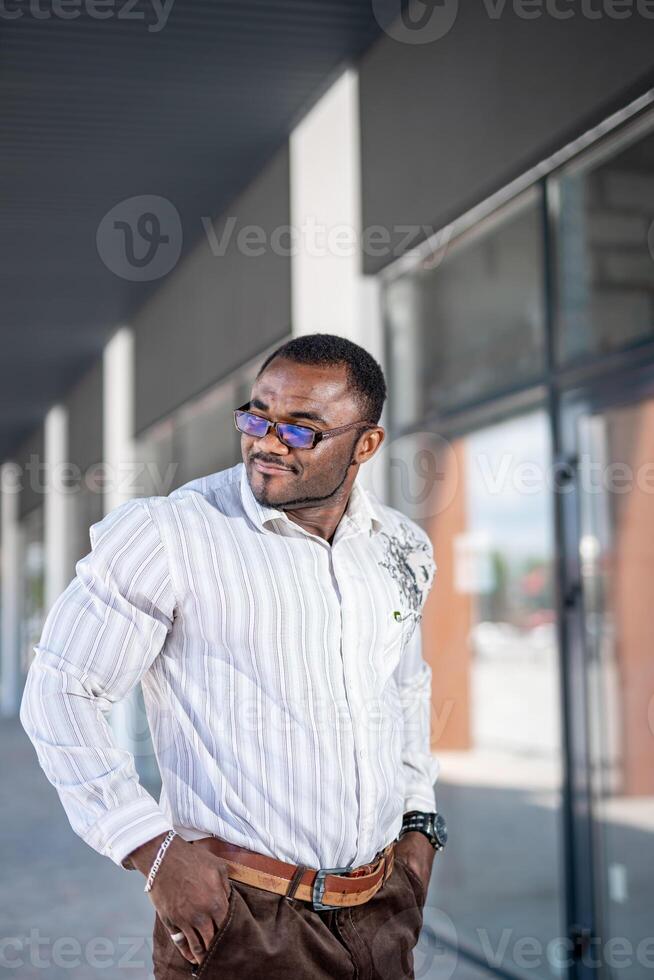 bonito à moda homem dentro casual roupas em urbano rua. escritório Gerente dentro branco camisa. foto