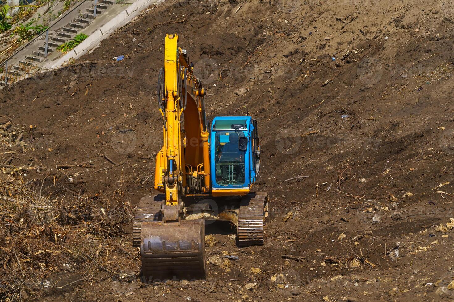 retroescavadeira amarela com braço de pistão hidráulico contra céu azul claro. máquina pesada para escavação no canteiro de obras. máquinas hidráulicas. enorme escavadora. indústria de máquinas pesadas. Engenharia Mecânica. foto