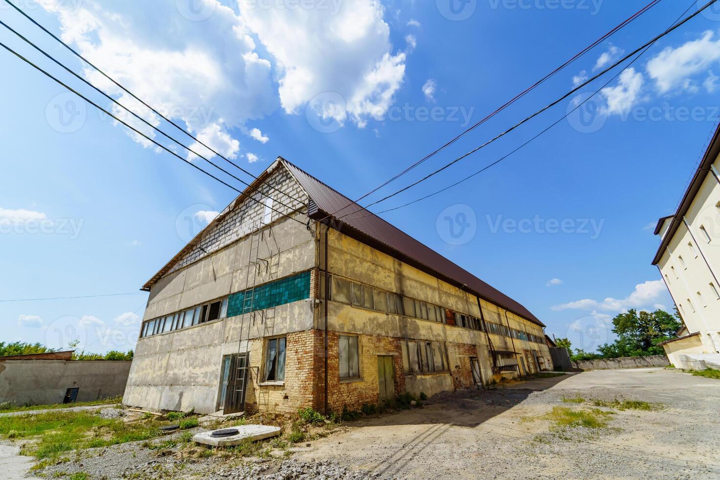 abandonado fábrica casa. velho industrial construção ao ar livre Visão em ensolarado verão dia. foto