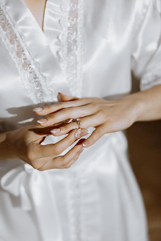 fechar-se do a elegante diamante anel em uma mulher dedo com uma moderno manicure, luz solar. amor e Casamento conceito. suave e seletivo foco. foto
