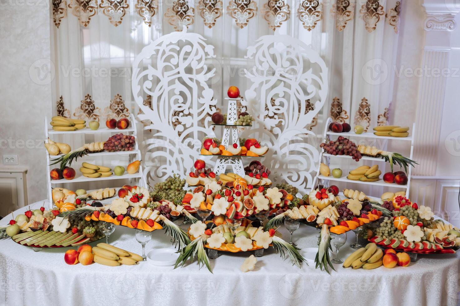 uma banquete mesa cheio do frutas e bagas, a sortimento do doces. bananas, uvas, abacaxis. fruta composições para a feriado. foto